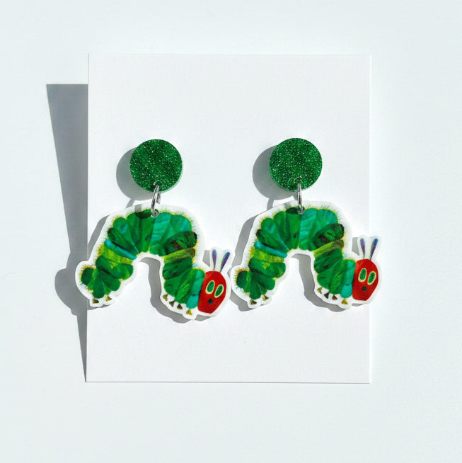 Green caterpillar-shaped earrings on a &