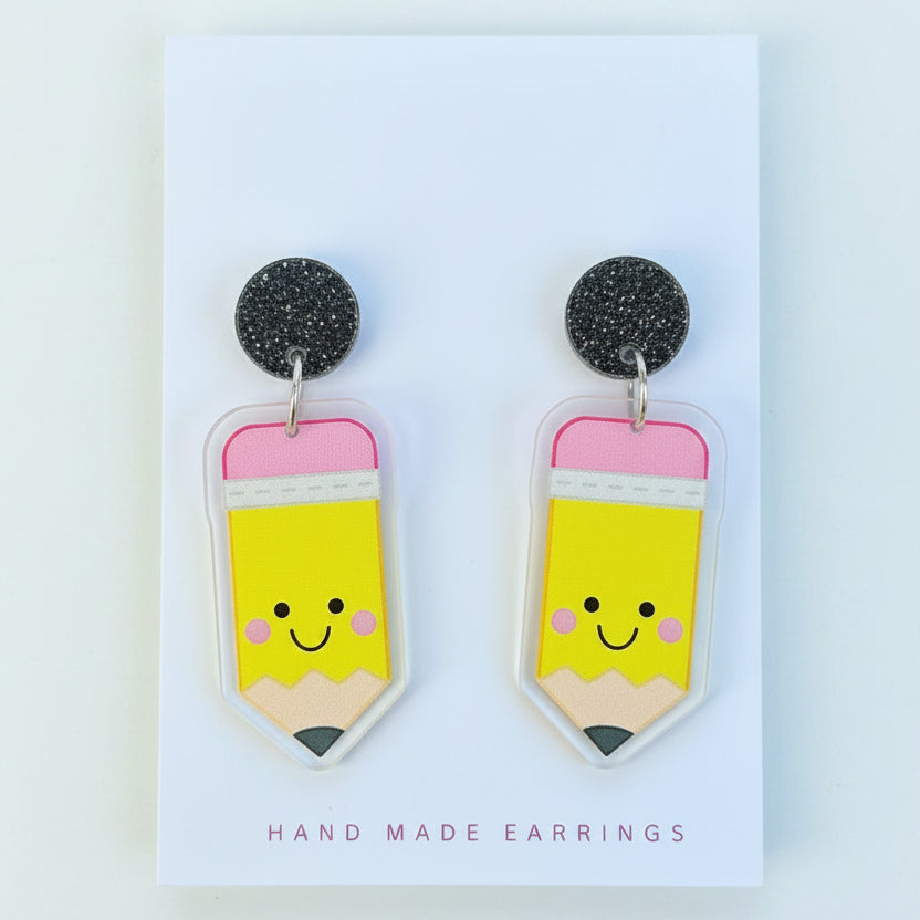 Pair of yellow pencil-shaped earrings on a &